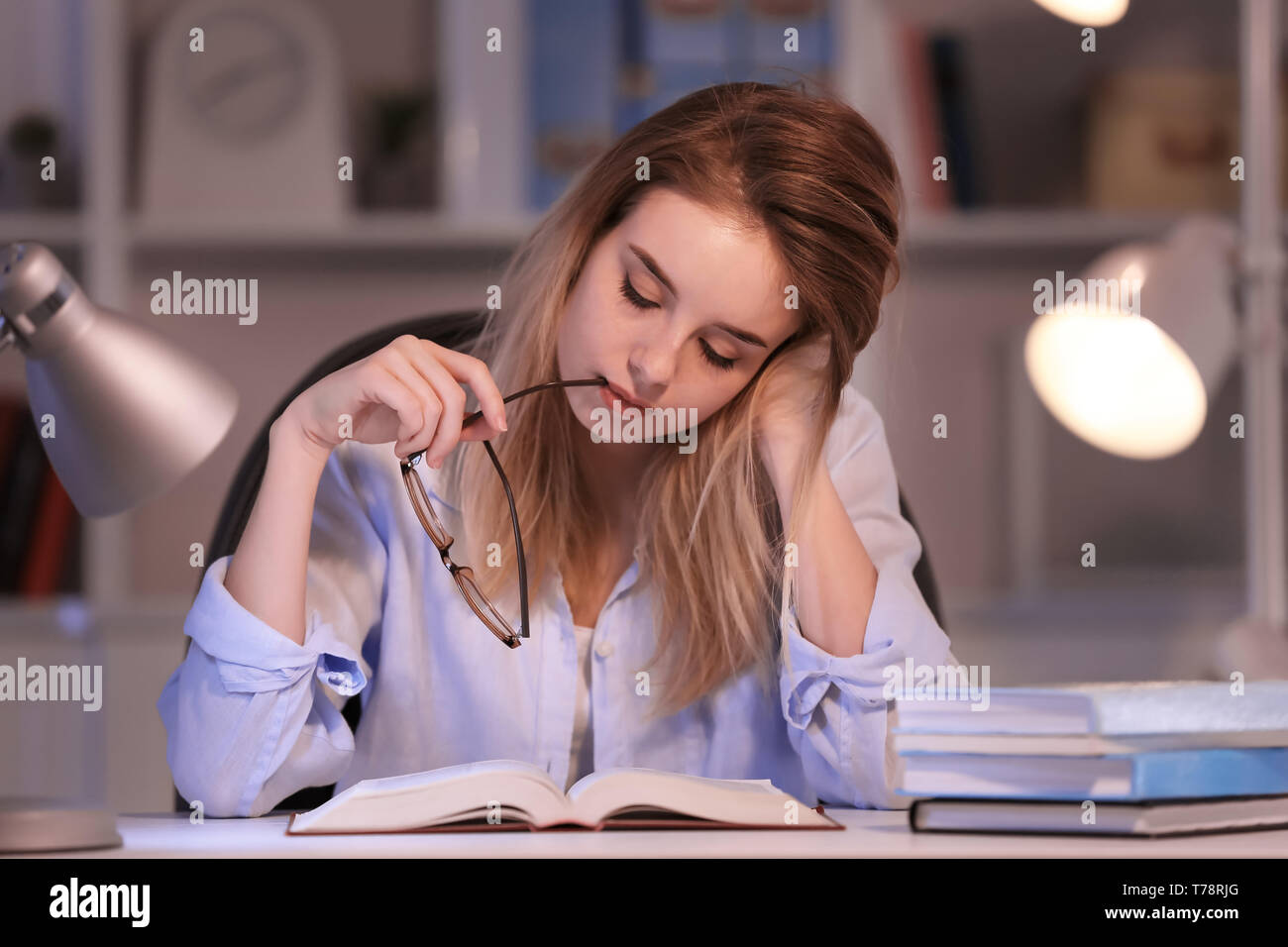 Reading Infromation Evening Young woman reading book at table in evening Stock Photo - Alamy