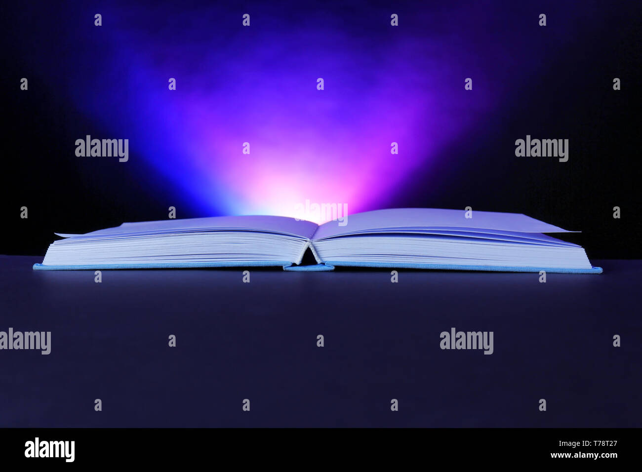 Open book with glowing on dark background Stock Photo