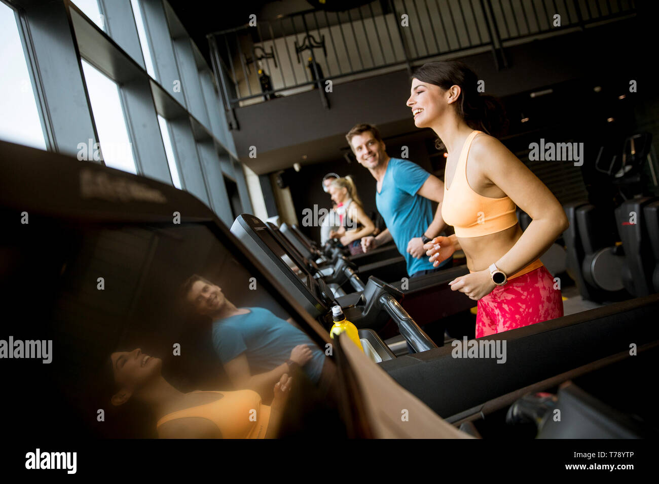 Group of young people running on treadmills in modern gym Stock Photo ...