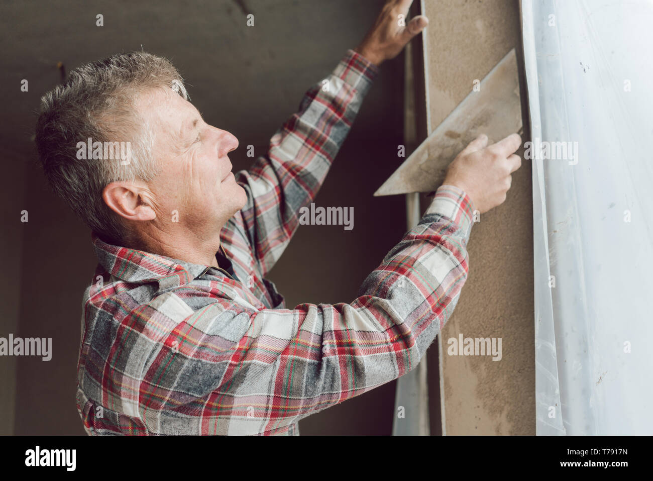 Diligent plasterer working on a window opening Stock Photo