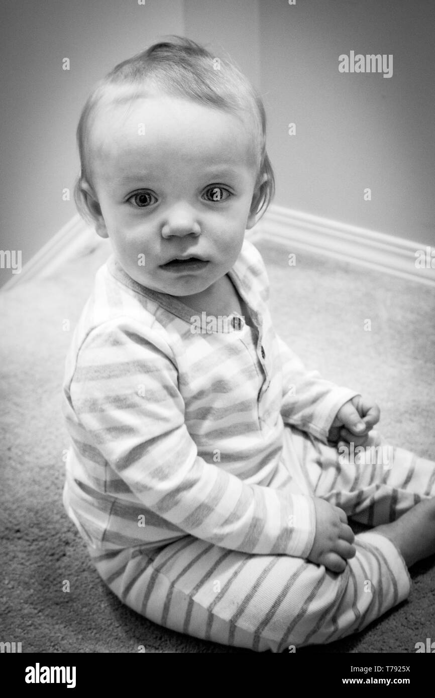 Toddler in his PJs sitting calmly with an intent stare. Stock Photo