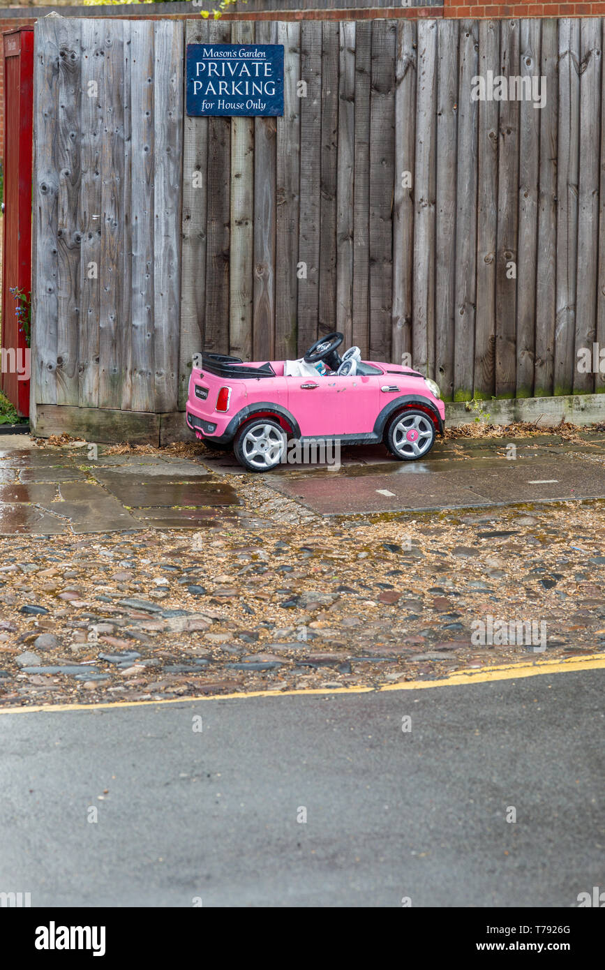 Humourous image of a small child's toy car parked below Private parking sign. Seen in Cambridge, England, UK. Stock Photo