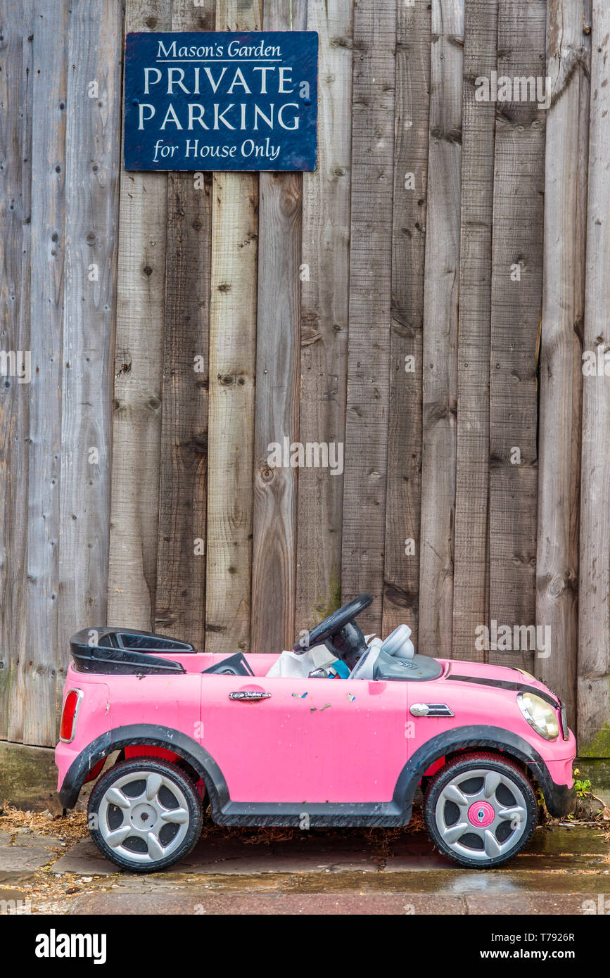 Humourous image of a small child's toy car parked below Private parking sign. Seen in Cambridge, England, UK. Stock Photo