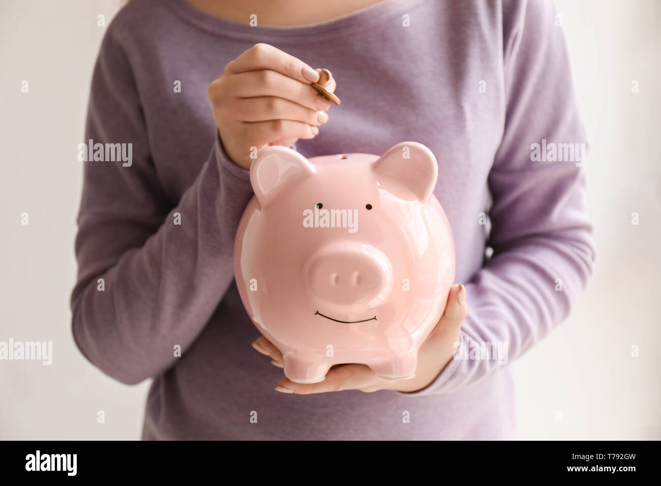 Woman putting coin into piggy bank. Money savings concept Stock Photo ...