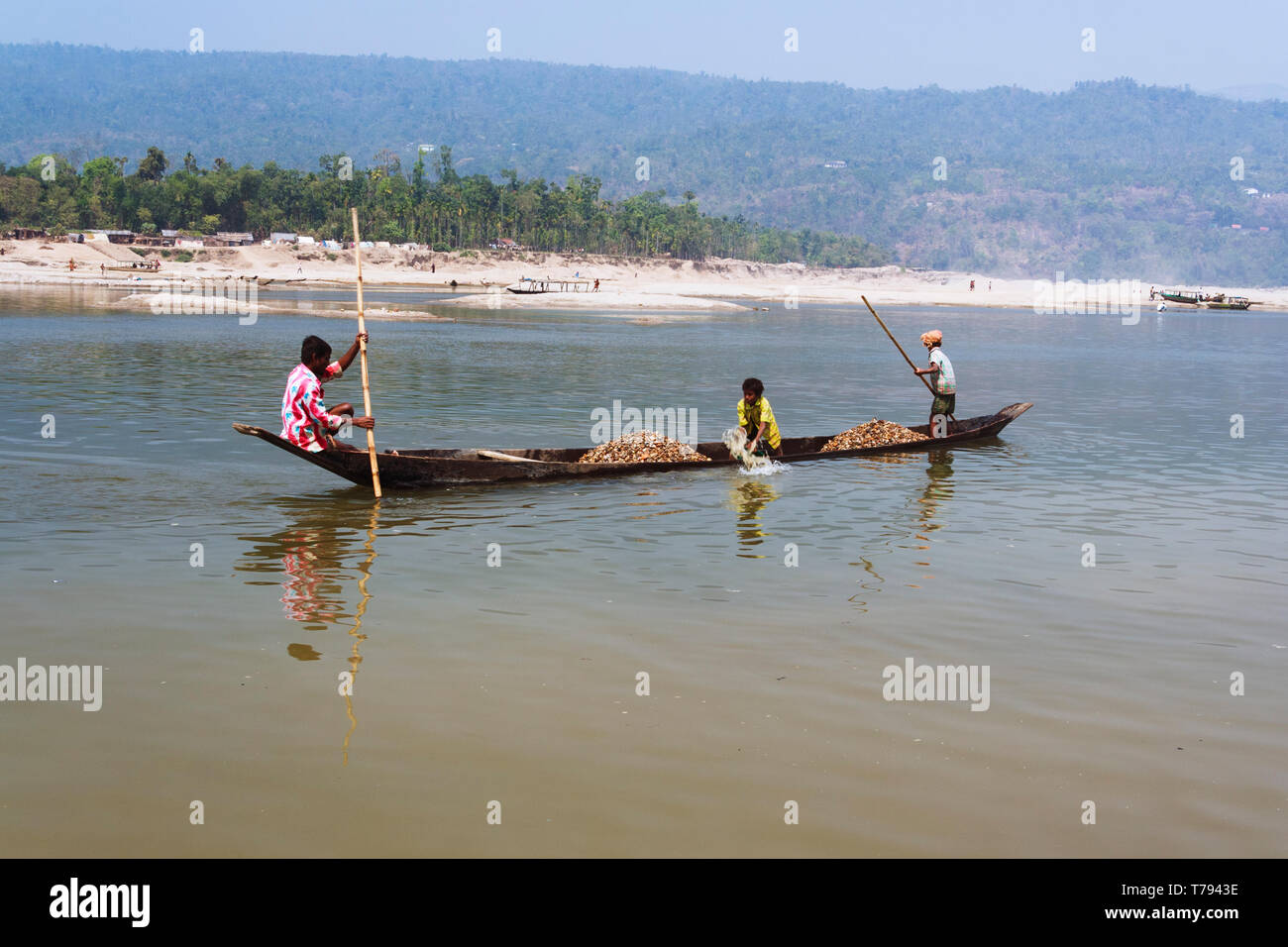 Jaflong, Sylhet, Bangladesh : Mari River. Bangladeshi family on a small boat collecting stones and boulders to be used in construction sites. Whole fa Stock Photo
