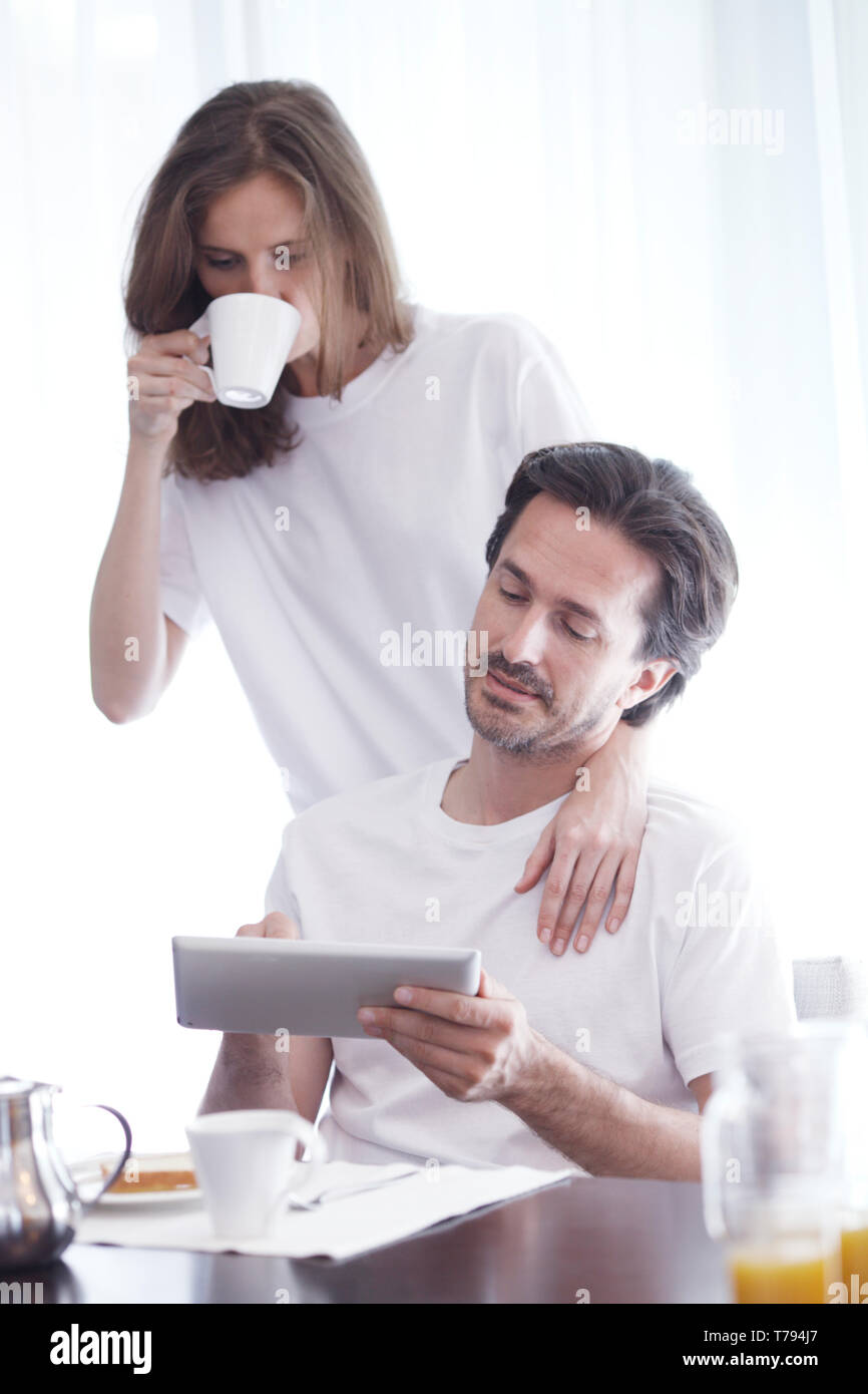 Couple having breakfast at home and using tablet Stock Photo