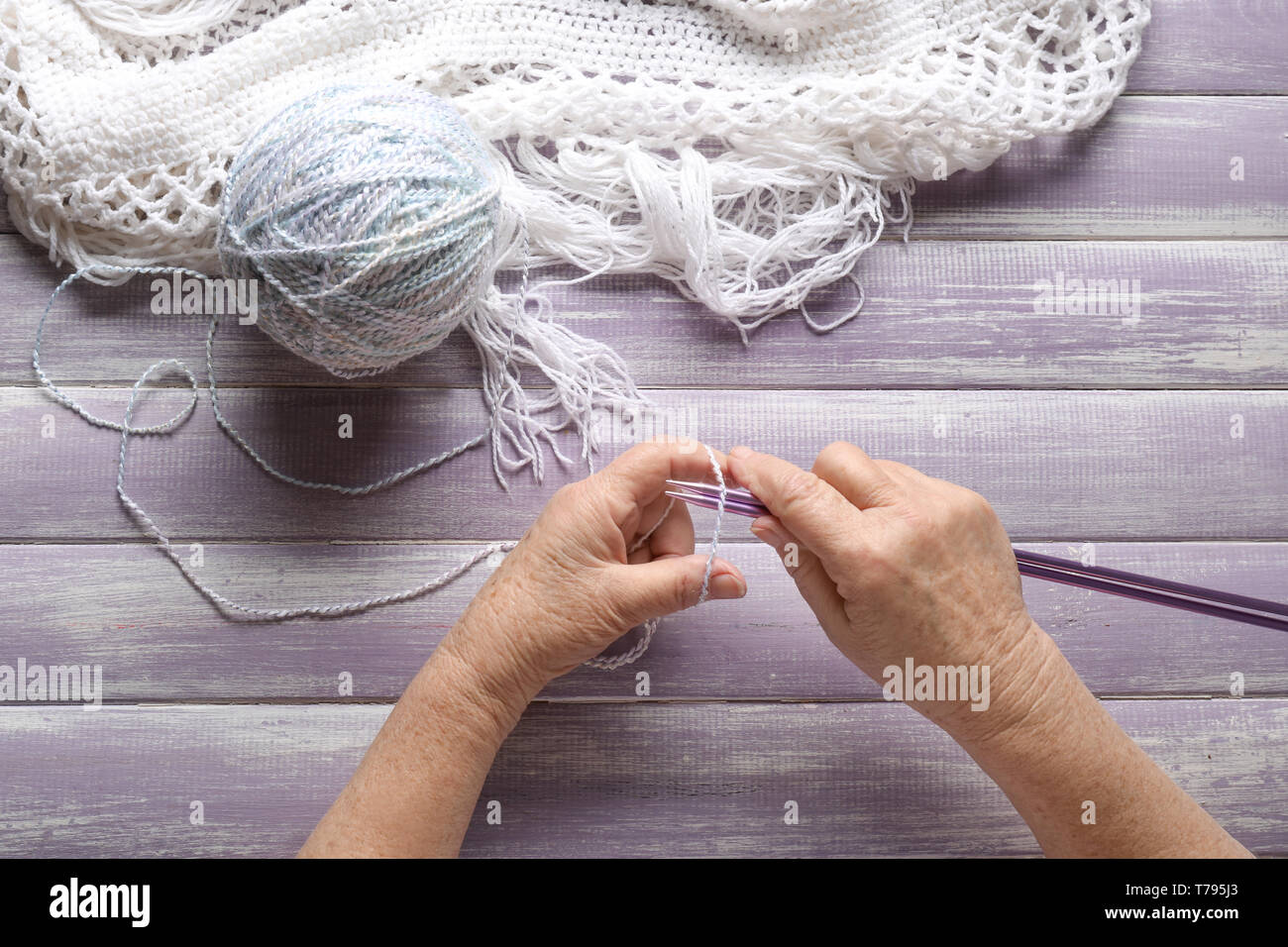 Senior woman knitting sweater at table Stock Photo - Alamy