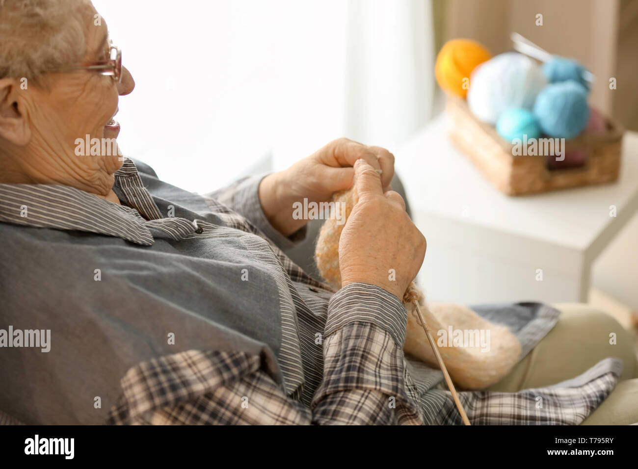 Senior woman knitting sweater at home Stock Photo - Alamy