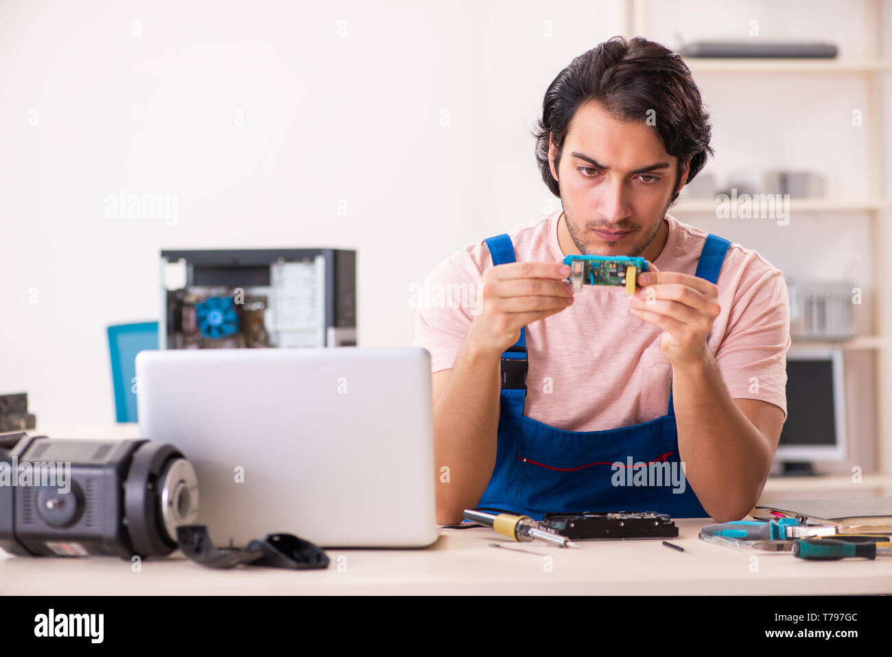 Young male contractor repairing computer Stock Photo
