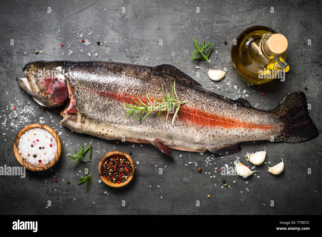Raw salmon fish whole with ingredients for cookings on black Stock ...