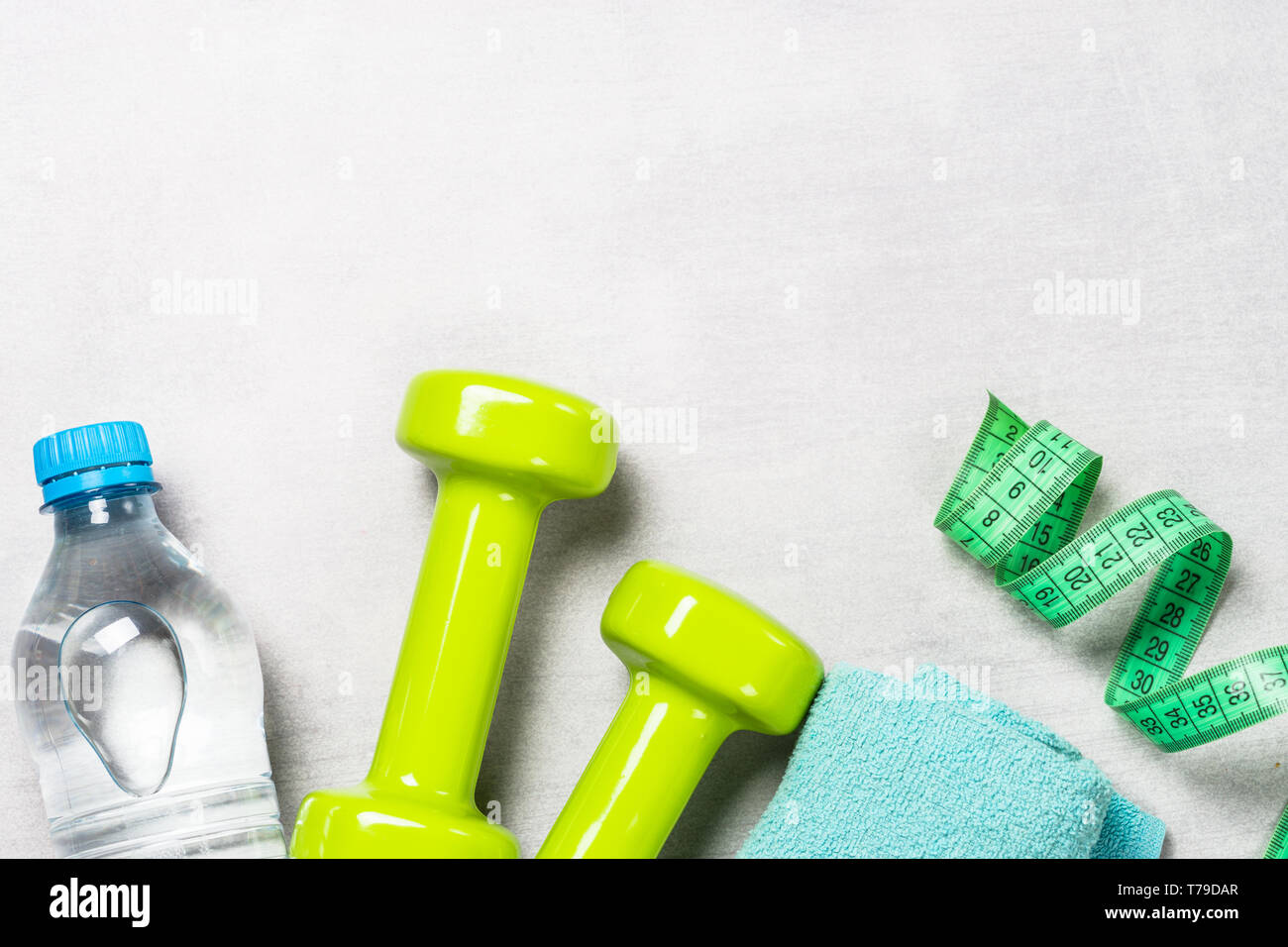 Dumbbells, measuring tape, water and apple top view. Stock Photo