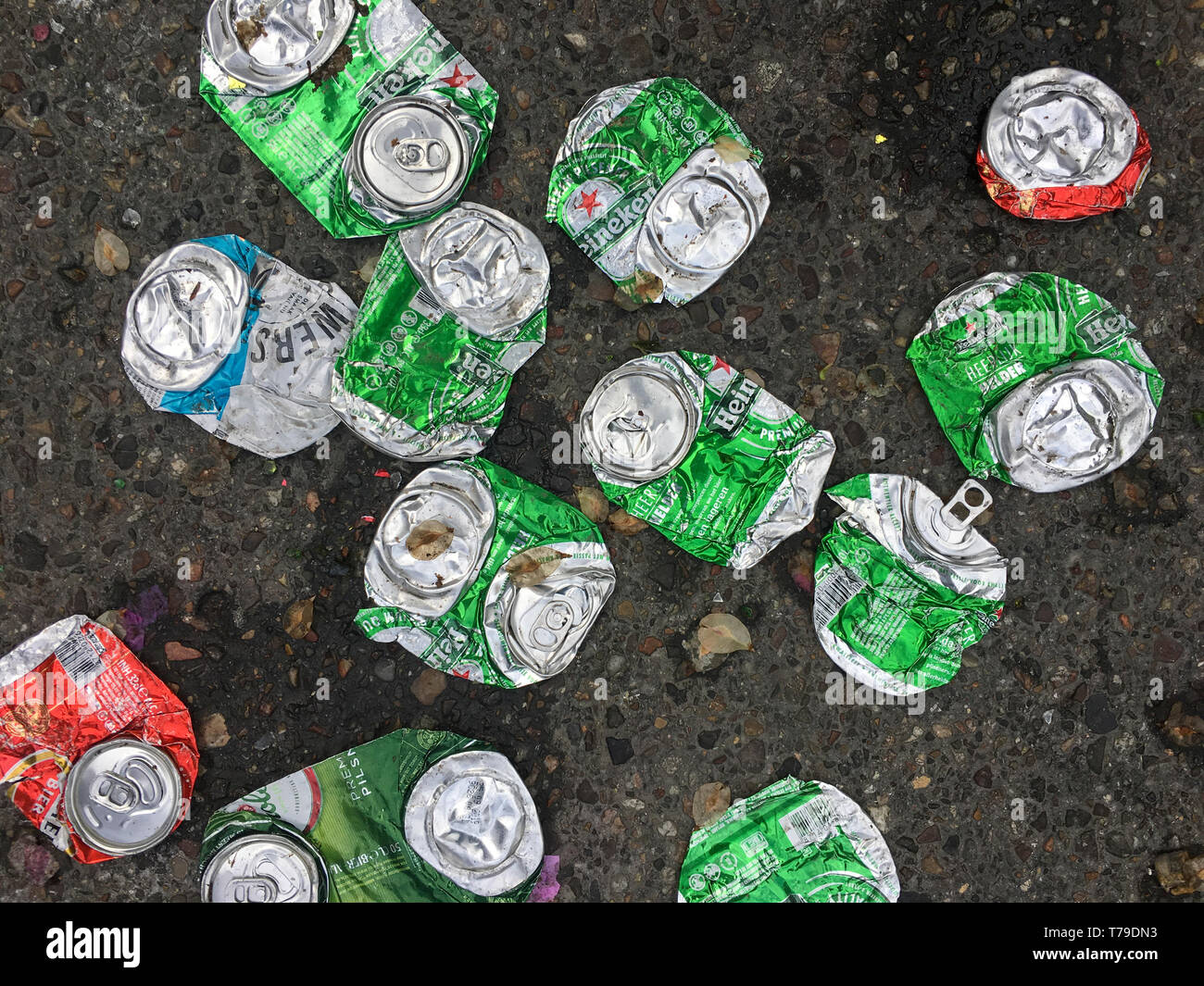 Many empty crushed aluminum beer cans are littering a street of Amsterdam city. Stock Photo