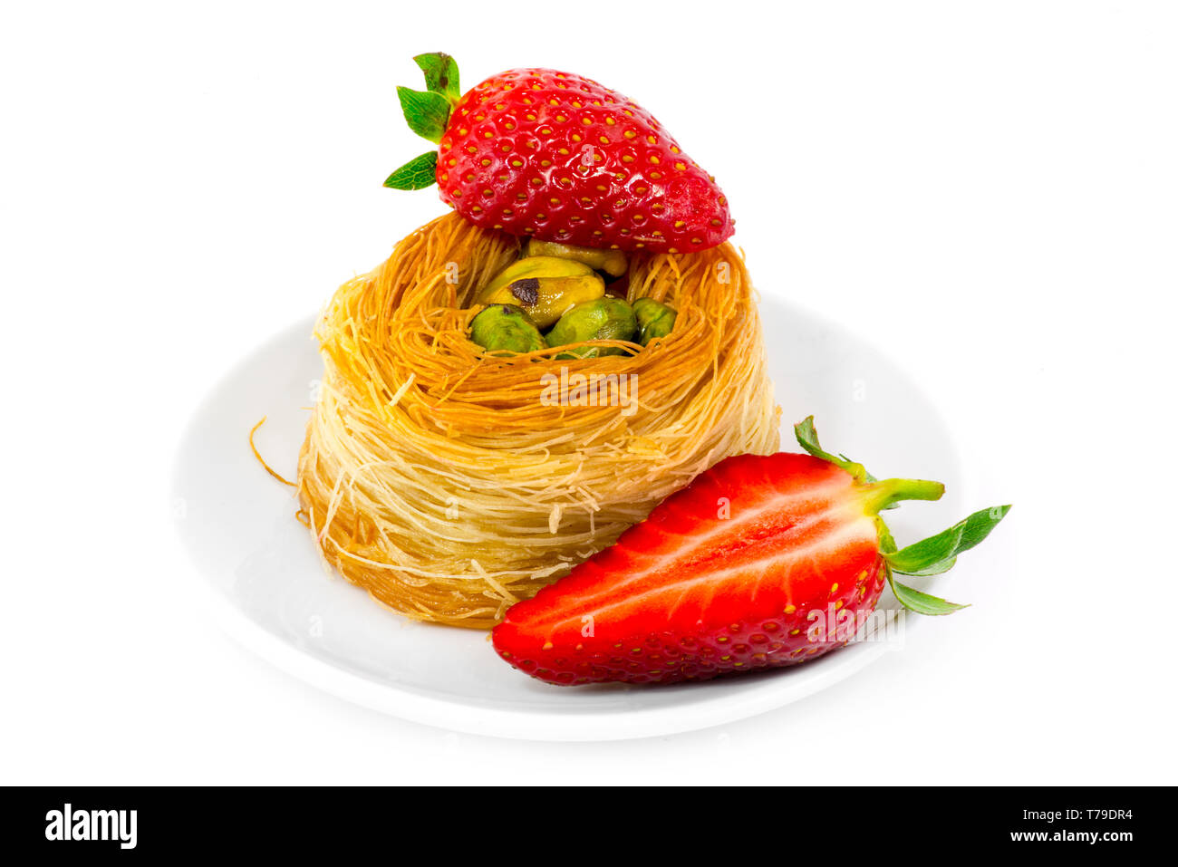 Kadaif with pistachios and strawberries. Traditional Arabic dessert. Stock Photo