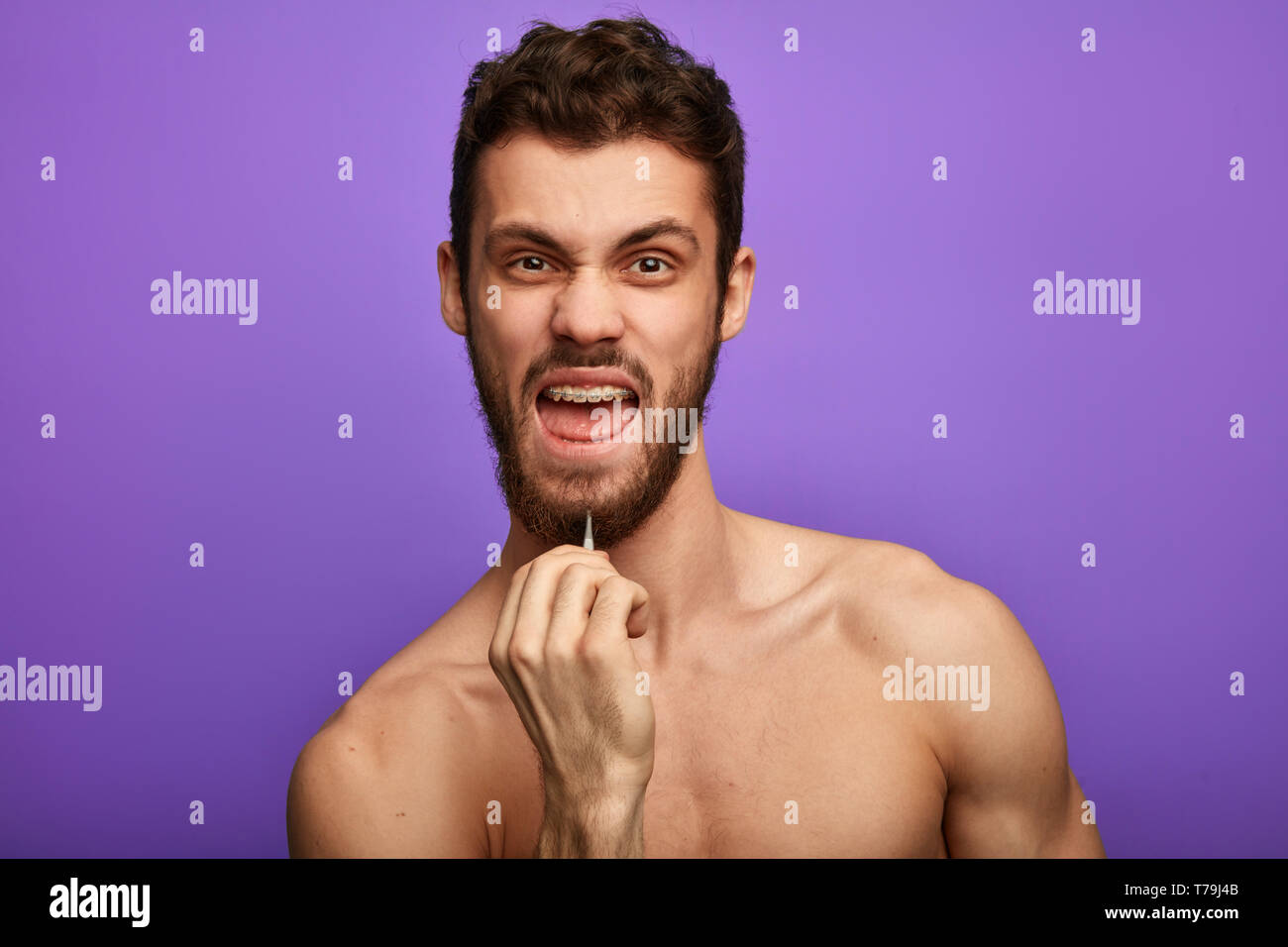 new method of depilation, crazy funny man using tweezers to remove his  beard. guy trying to rid of the beard. close up portrait Stock Photo - Alamy