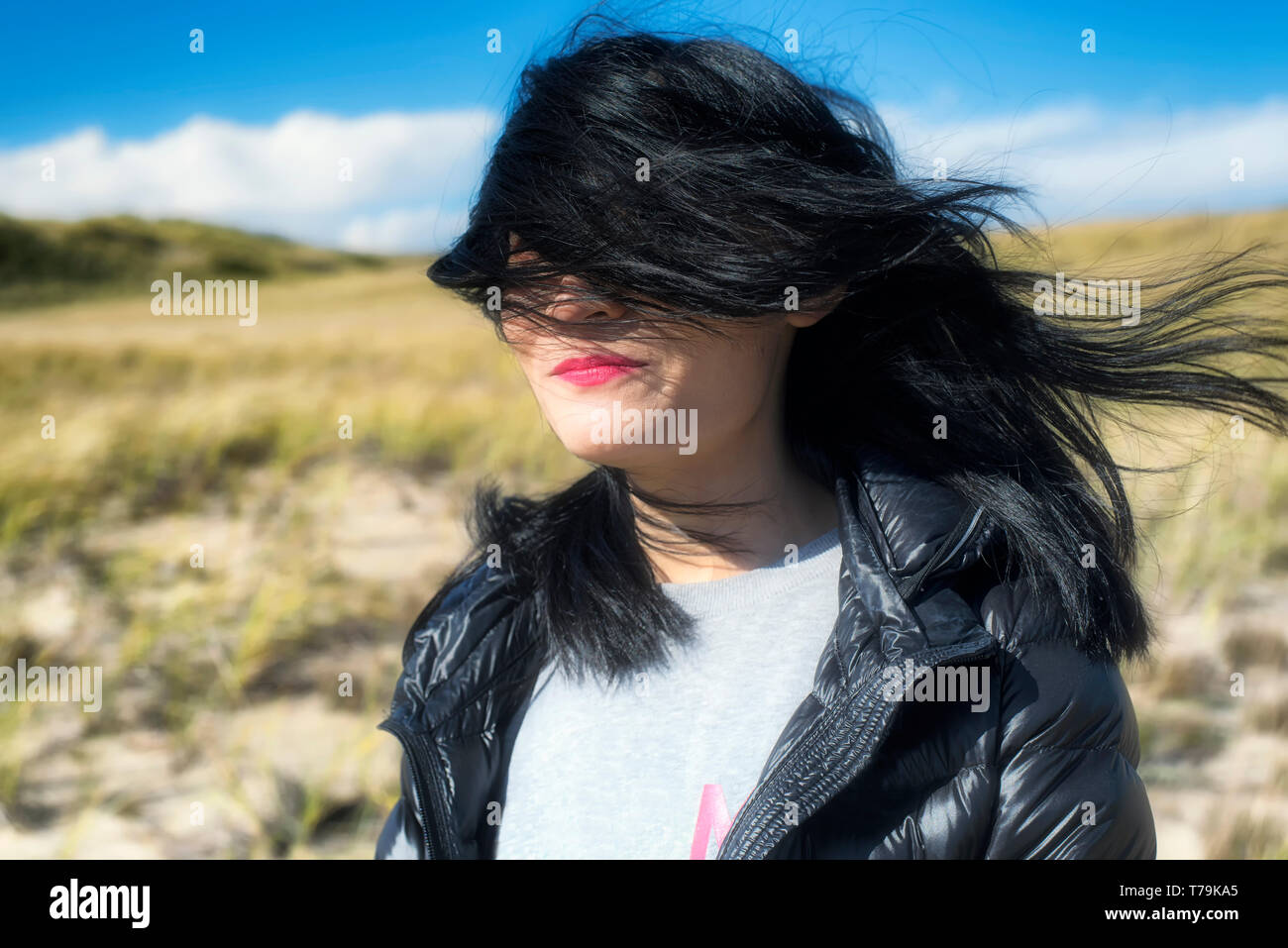 A woman's wind blown hair outside on a sunny day on the cape cod national seashore in Truro Massachusetts. Stock Photo