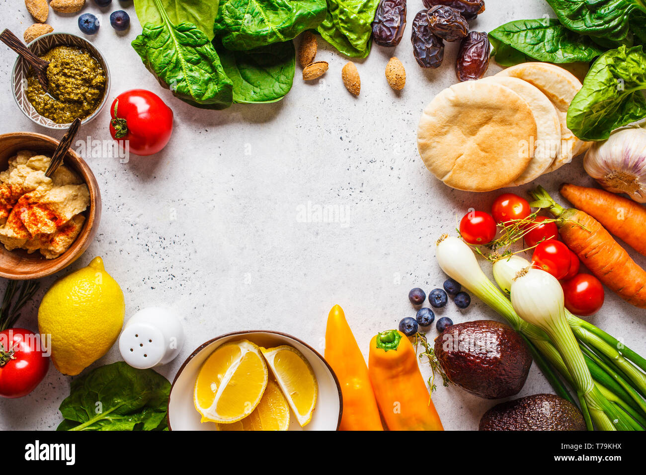 Healthy vegetarian food background. Vegetables, hummus, pesto and fruits. Stock Photo