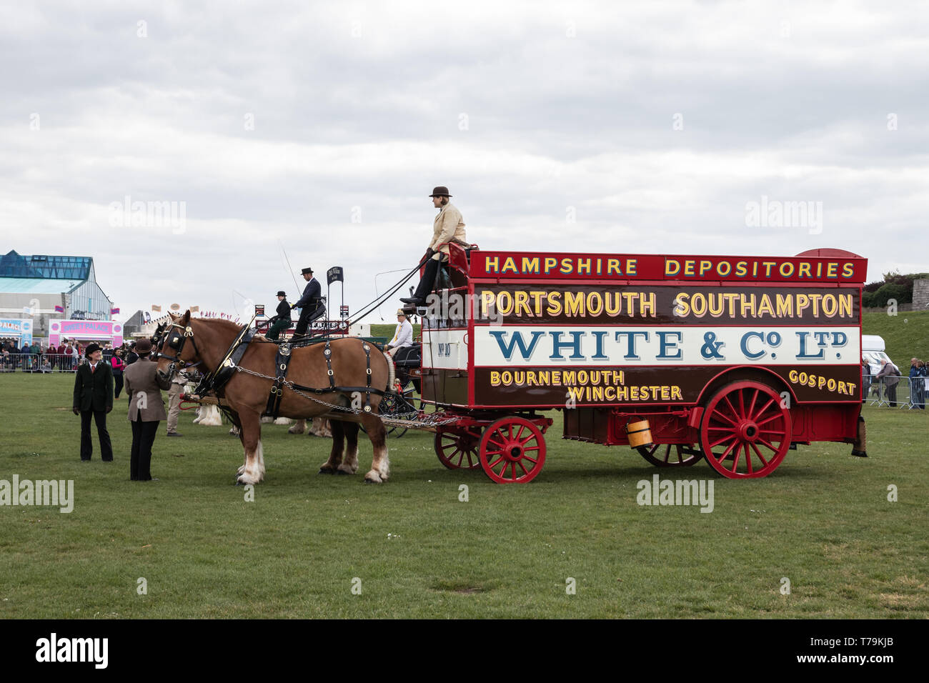 Carriage or trailer being pulled by heavy horses at a horse show in the