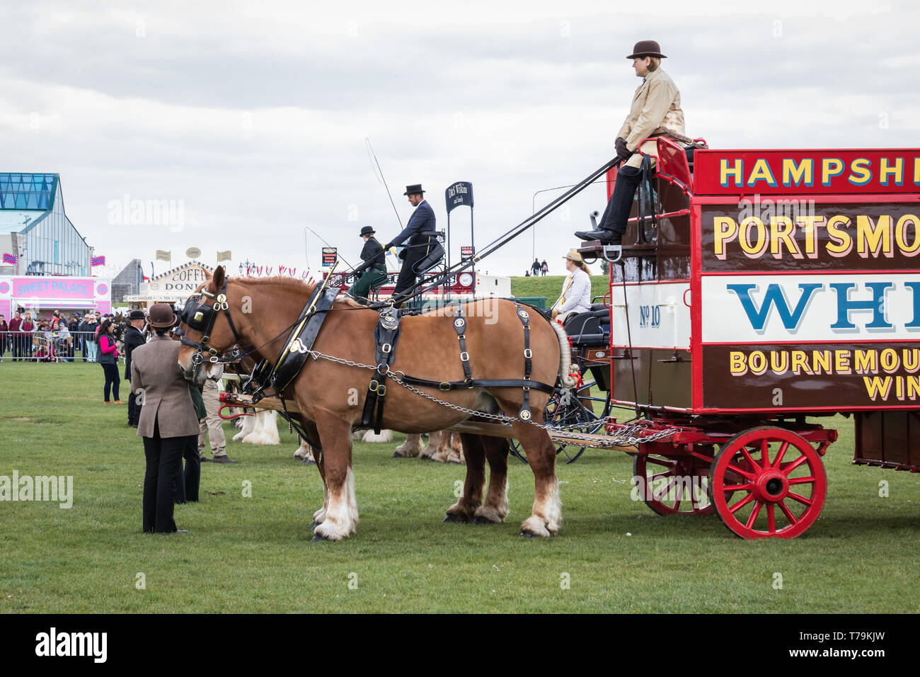 Carriage or trailer being pulled by heavy horses at a horse show in the