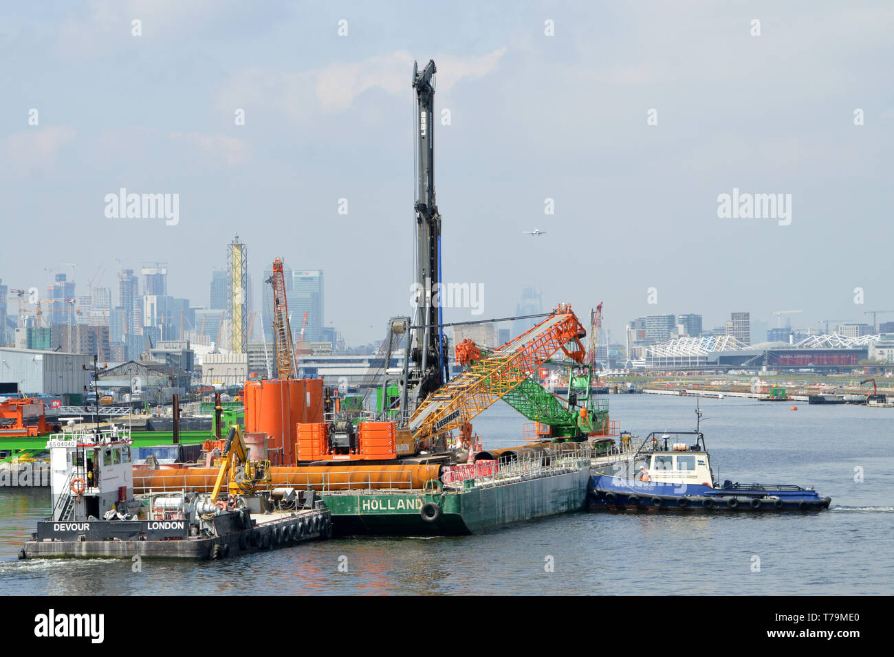 Tugs moving an engineering barge in the King George V Dock, London, as part of the London City Airport CADP expansion works Stock Photo