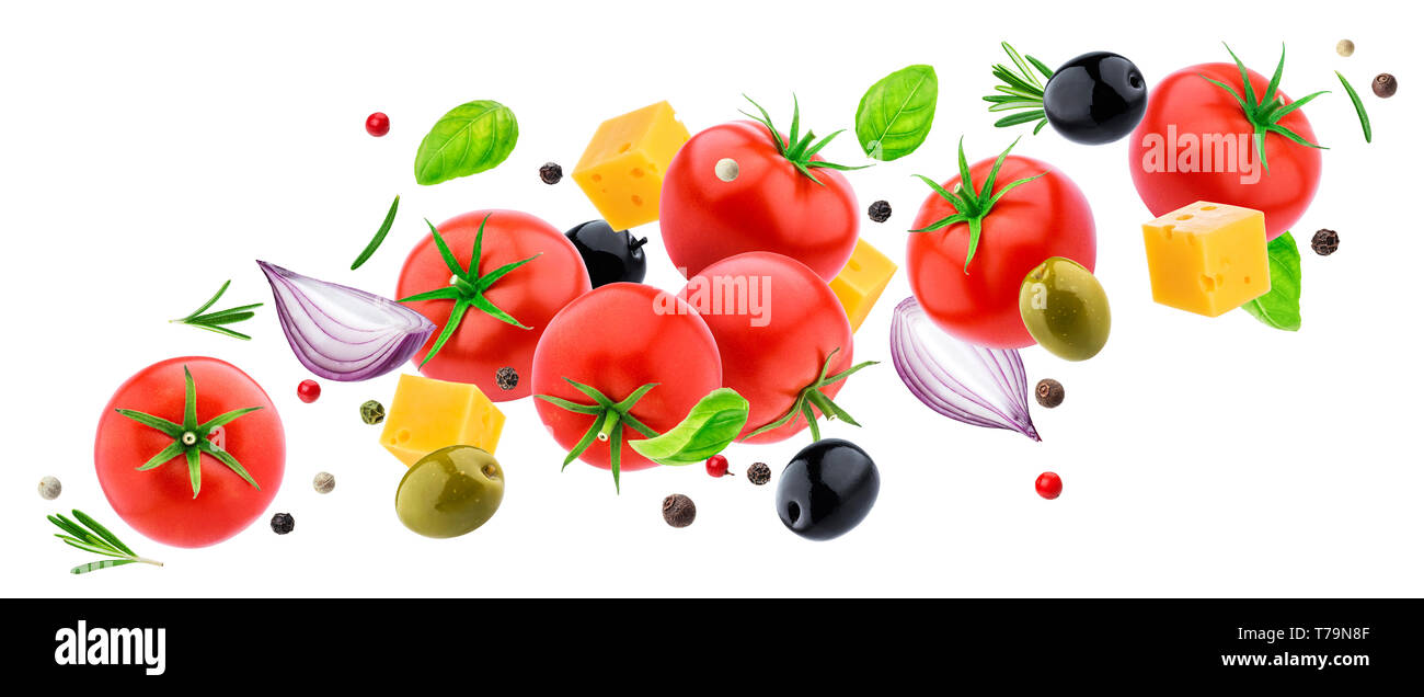 Flying vegetable salad isolated on white background with clipping path, mix of falling fresh salad ingredients: tomatoes, herbs, cheese, olives, basil Stock Photo
