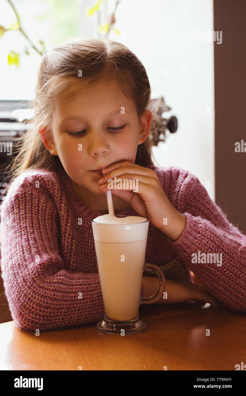 Girl drinking strawberry cocktail from a straw in a cafe Stock Photo