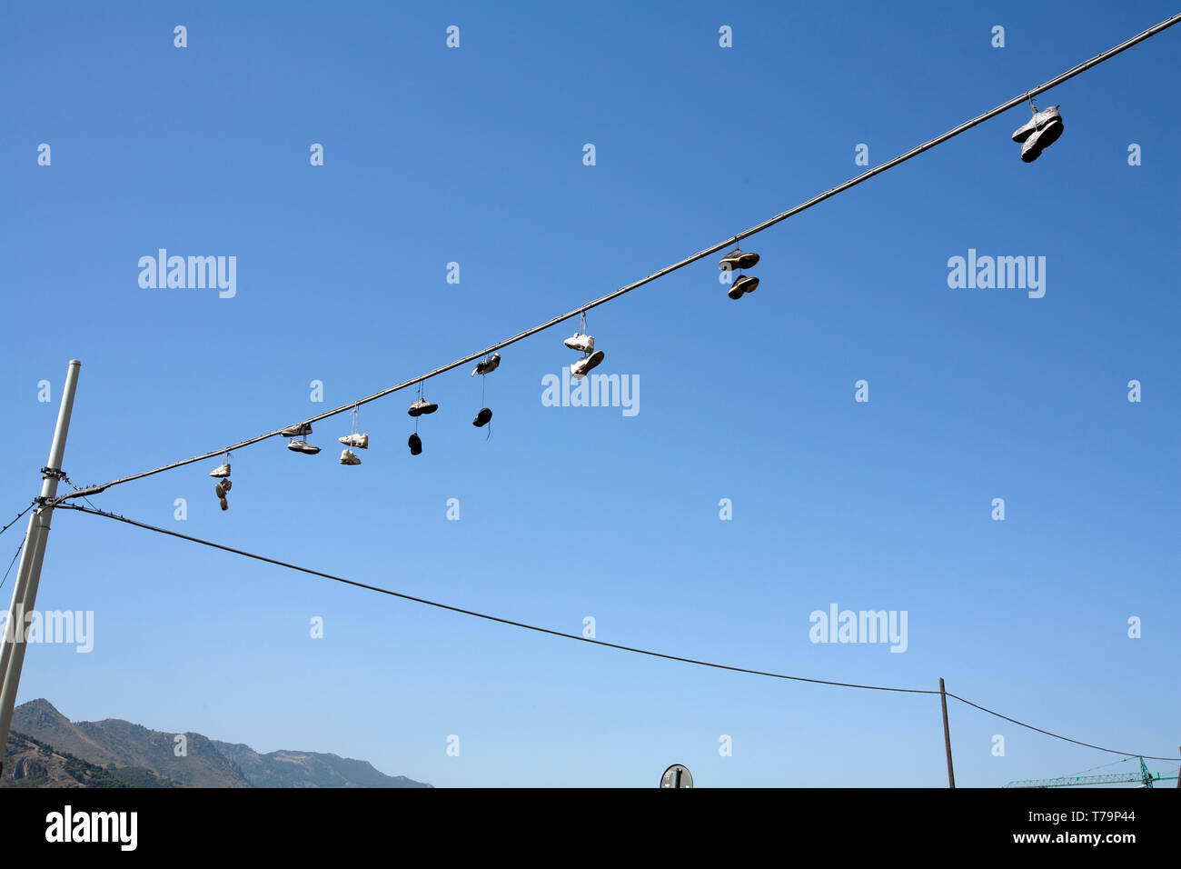 Shoes hanging from telephone lines as an international sign of drugs sale in the area Stock Photo