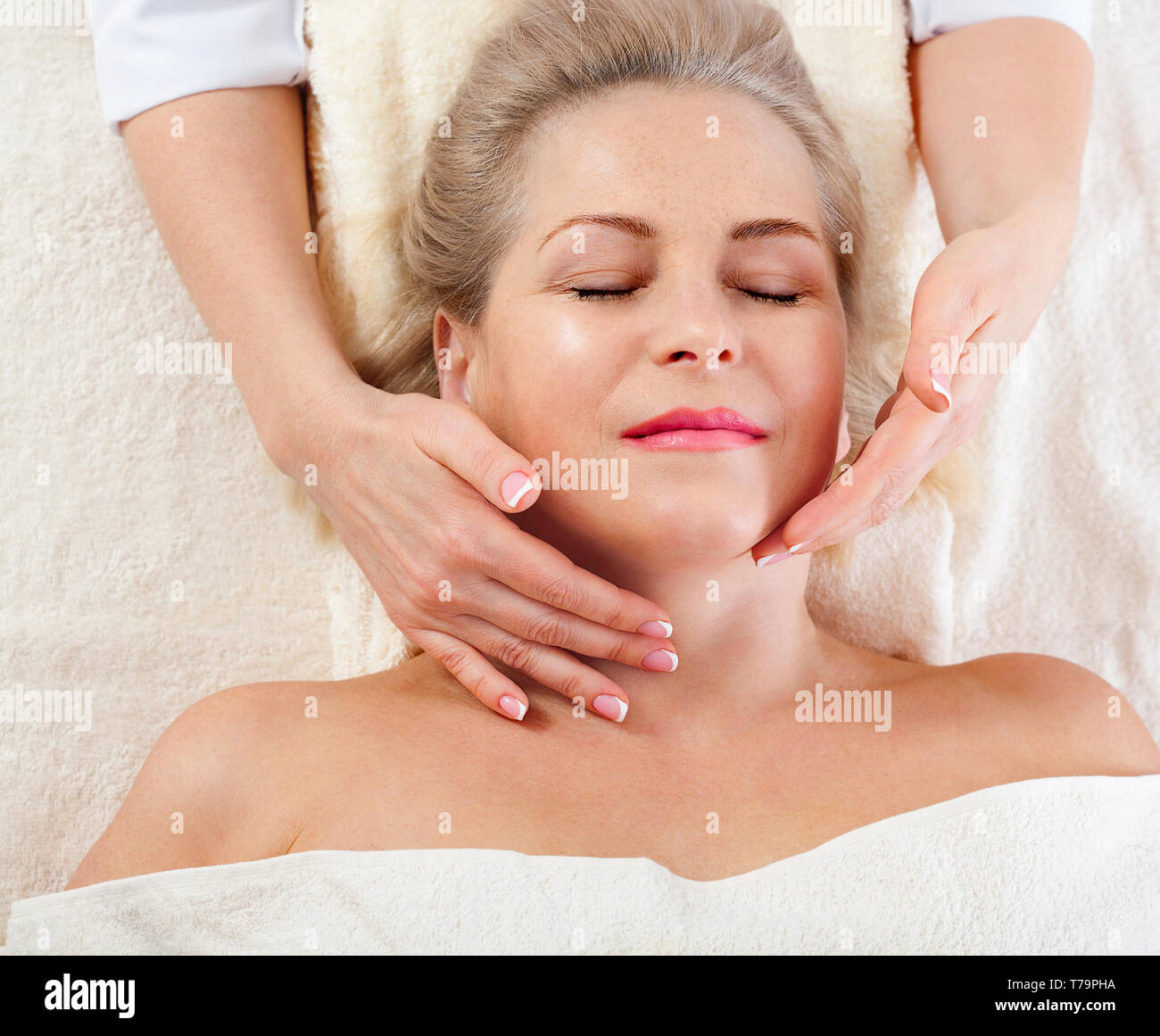 beautiful woman doing facial massage in a spa salon. selective focus. Stock Photo
