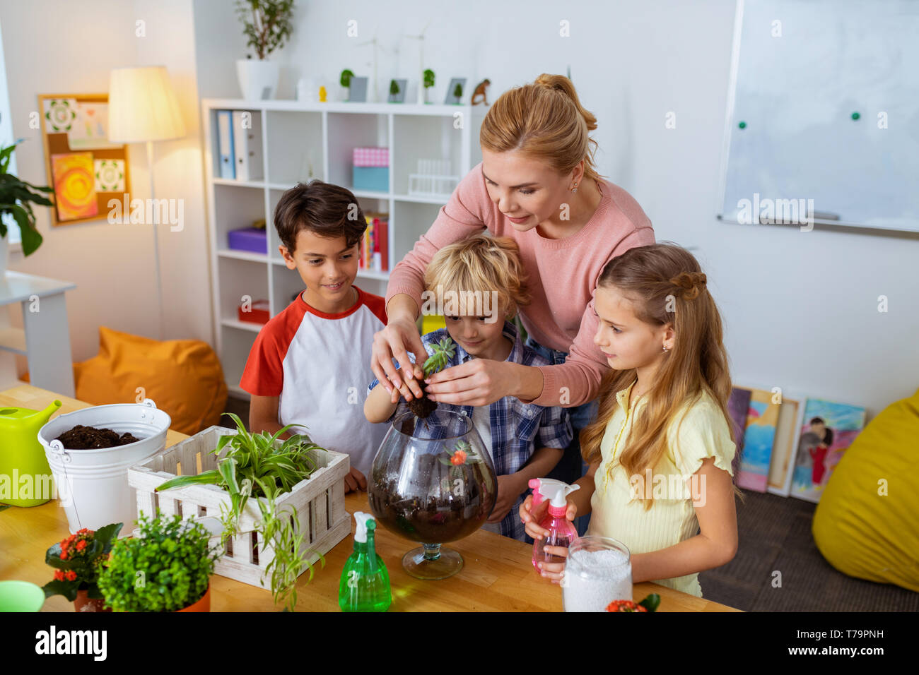 Teaching pupils. Helpful young smart botany teacher teaching her pupils