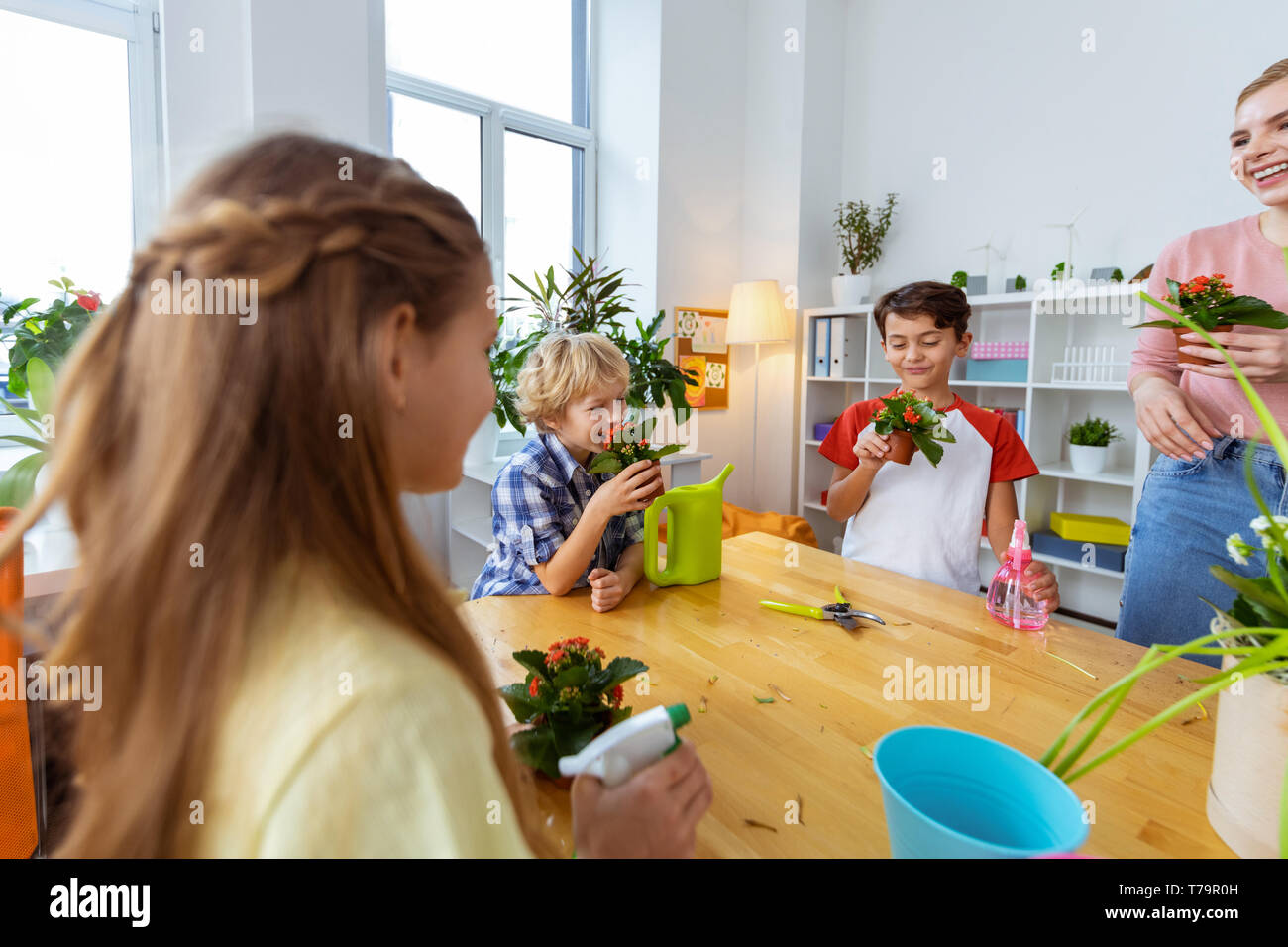 With red flowers. Cute goodlooking pupils and teachers smelling red