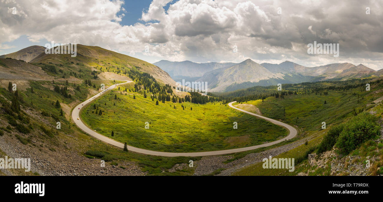Wide panorama of the view over a large horseshoe bend on Cottonwood pass in Colorado USA with cars racing towards the summit Stock Photo