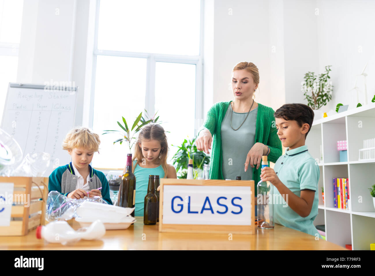 Glass Sorting Activity About glass recycling. Primary school teacher telling her pupils about ...