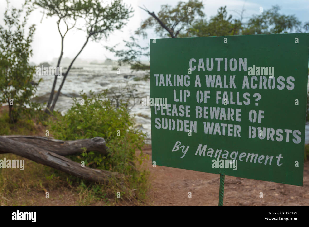 Closeup of a pedestrian warning sign of hazards associated with walking on dangerous lip of Victoria Falls in Africa Stock Photo