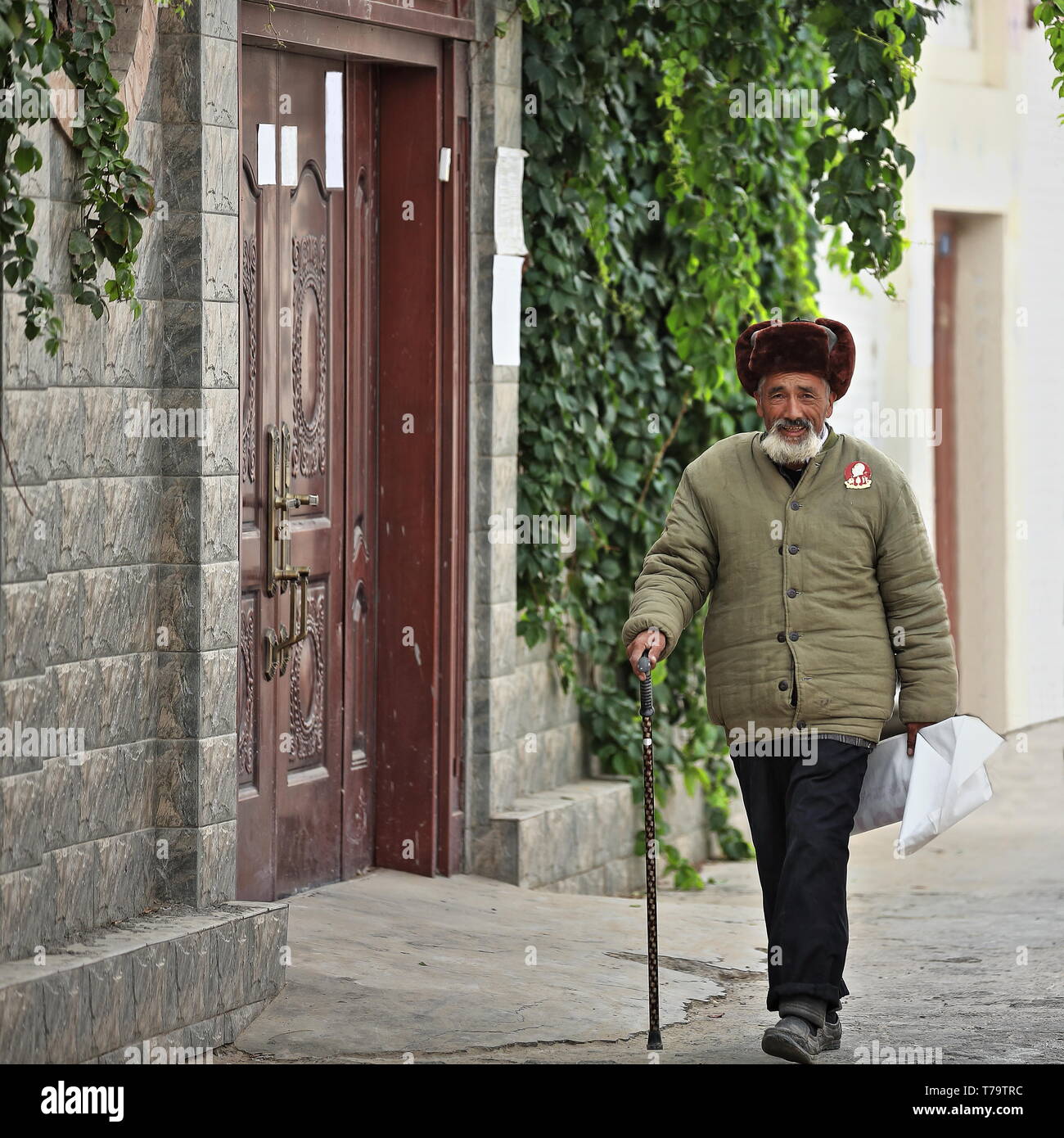 Uyghur old man with walking cane. Sunday Market rear area-Hotan-Xinjiang-China-0119 Stock Photo