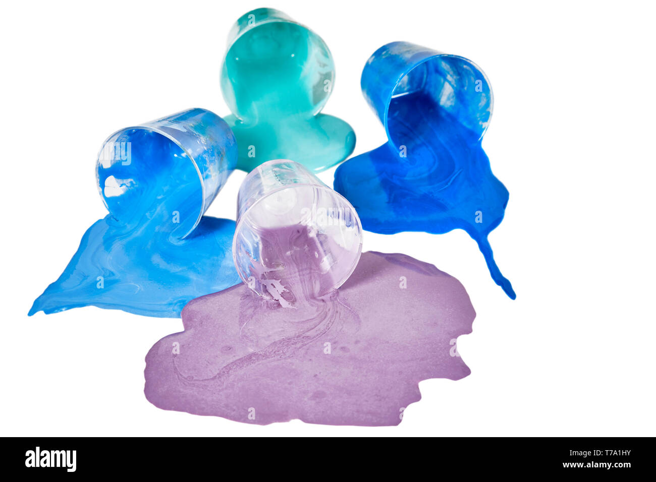 Small bowls of spilled lavender, blue and teal acrylic paint laying on its side isolated on white Stock Photo