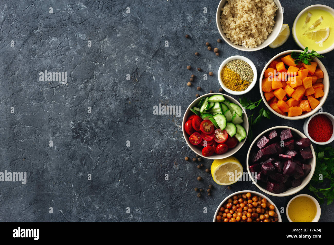 Set of healthy vegetarian ingredients for cooking. Spiced chickpeas, Baked pumpkin and beets, quinoa and vegetables on dark stone background with copy Stock Photo