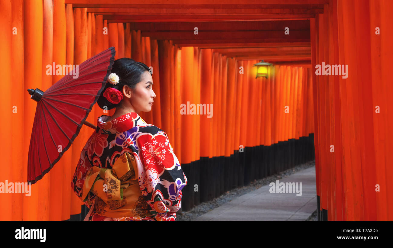 Women in traditional japanese kimonos walking at Fushimi Inari Shrine in Kyoto, Japan, Kimono women and umbrella, Kyoto Stock Photo