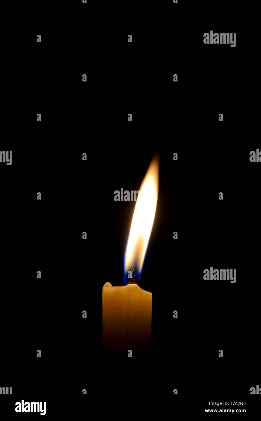 Single lighted candle in the dark Stock Photo