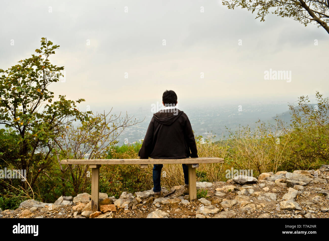 A young boy resting on a bench on a hill facing towards the city Stock Photo - Alamy A young boy resting on a bench on a hill facing towards the city Stock Photo - Alamy