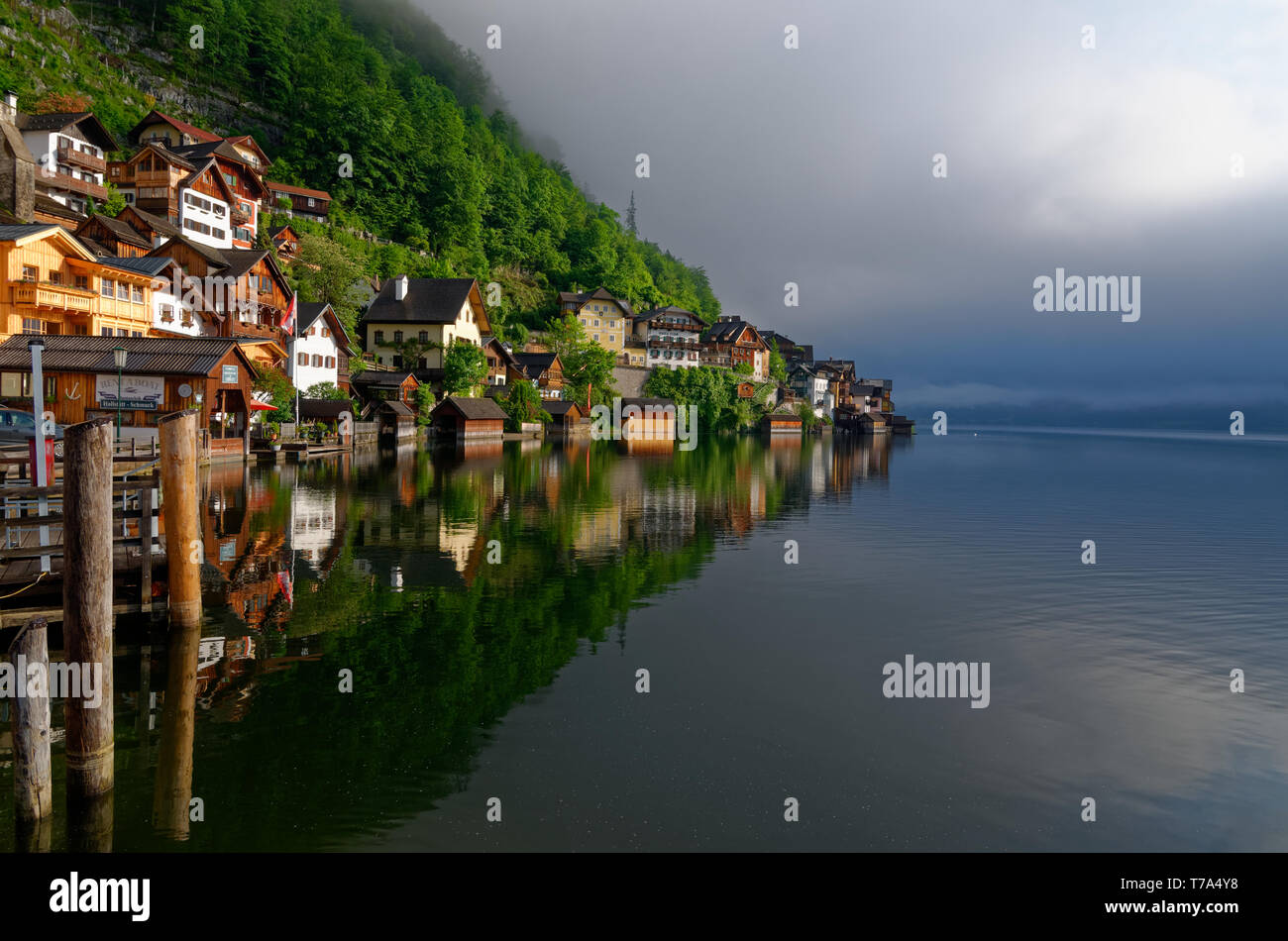 Early morning shot of Hallstatt houses and reflections in the water of Hallstatter See (Lake Hallstatt) with low cloud in the background Stock Photo