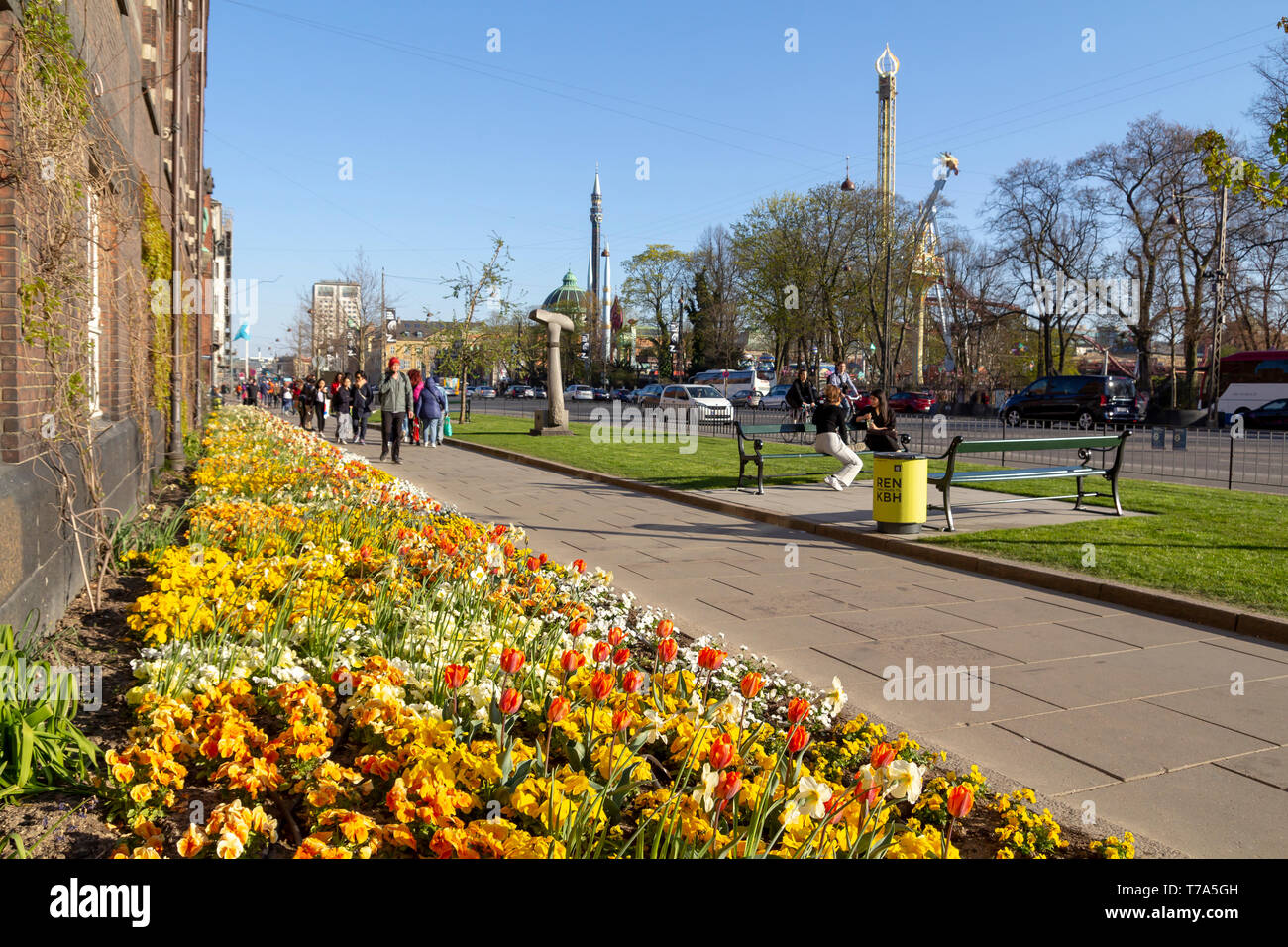 People walking in the street with beautiful flowers, next to the Tivoli amusement park in the city of Copenhagen Stock Photo