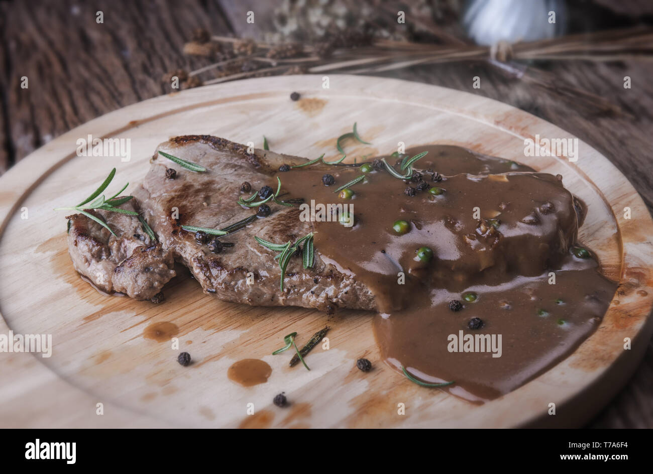 Pepper beef steak with herb and seasoning gravy sauce serve in wooden