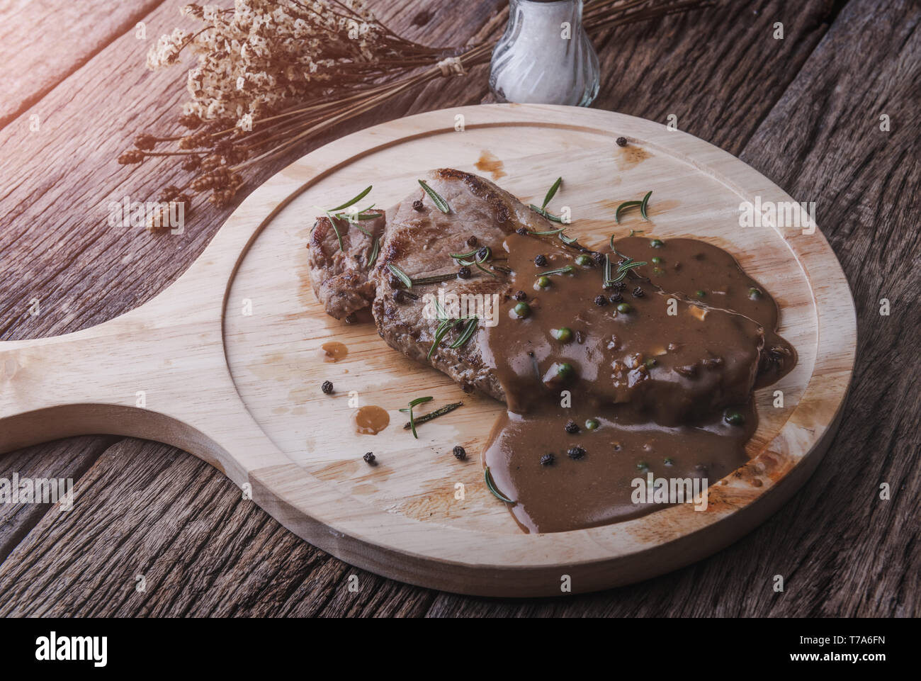 Pepper beef steak with herb and seasoning gravy sauce serve in wooden
