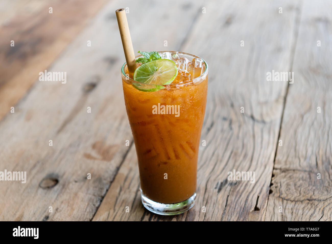 Ice cold sweet lemon tea drink  on the wooden table with outdoor sun lighting. Stock Photo