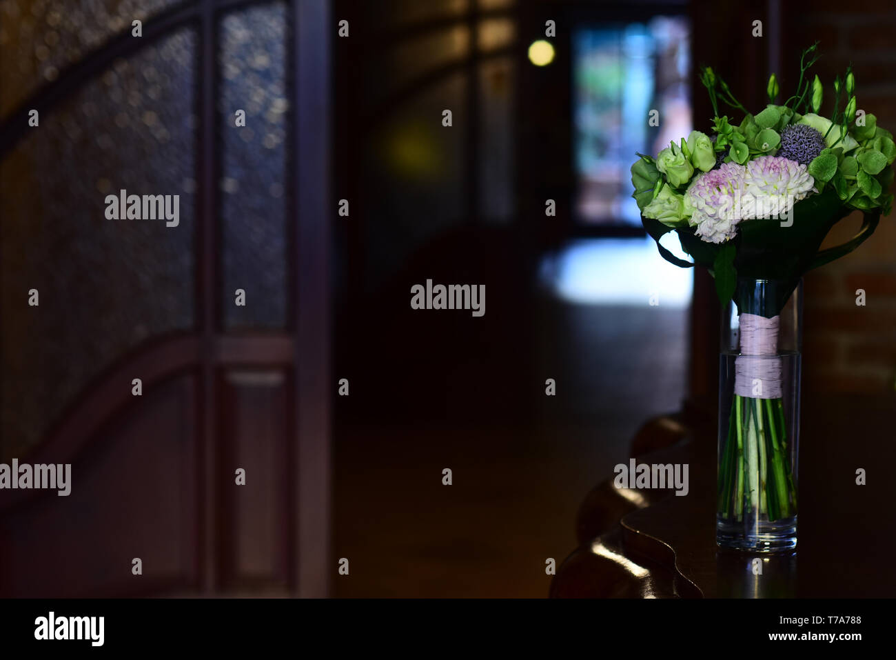 Flowers in glass vase on table in room Stock Photo