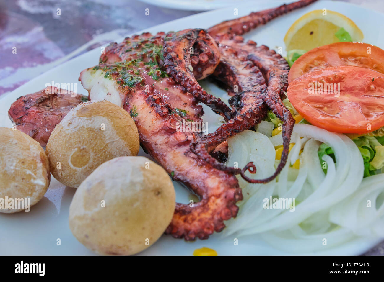 plate with octopus, potatoes and salad in a Spanish restaurant Stock Photo