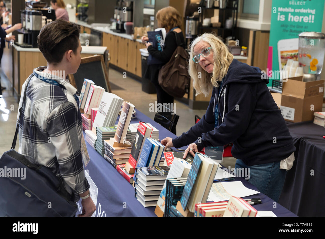 Seattle, Washington: Laurie Raisys, proprietar of Island Books, helps a customer at her pop-up bookshop at the Crosscut Festival. Seattle University h Stock Photo
