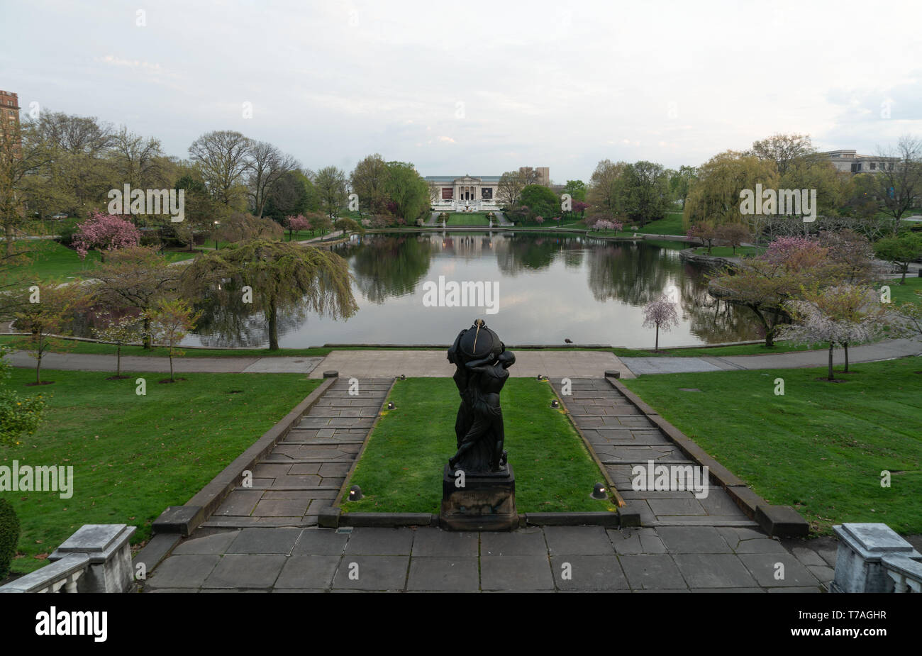 Cleveland, Ohio/USA - May 1, 2019: On the steps of the Wade Park Lagoon with the statue in the foreground and The Cleveland Museum of Art in the dista Stock Photo