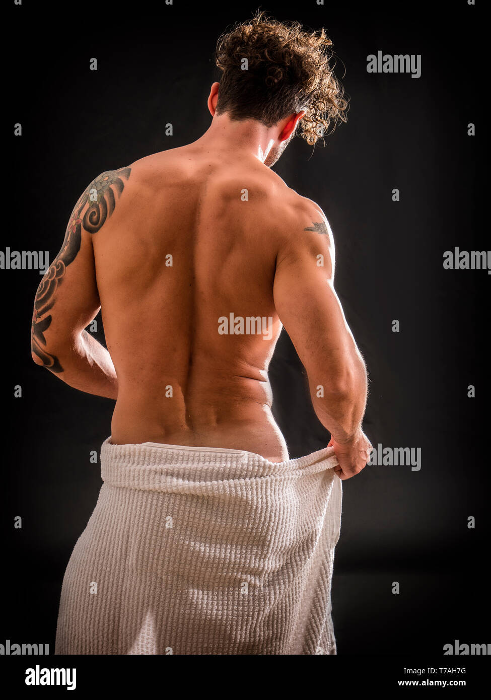 Naked muscular man covering crotch with towel Stock Photo - Alamy