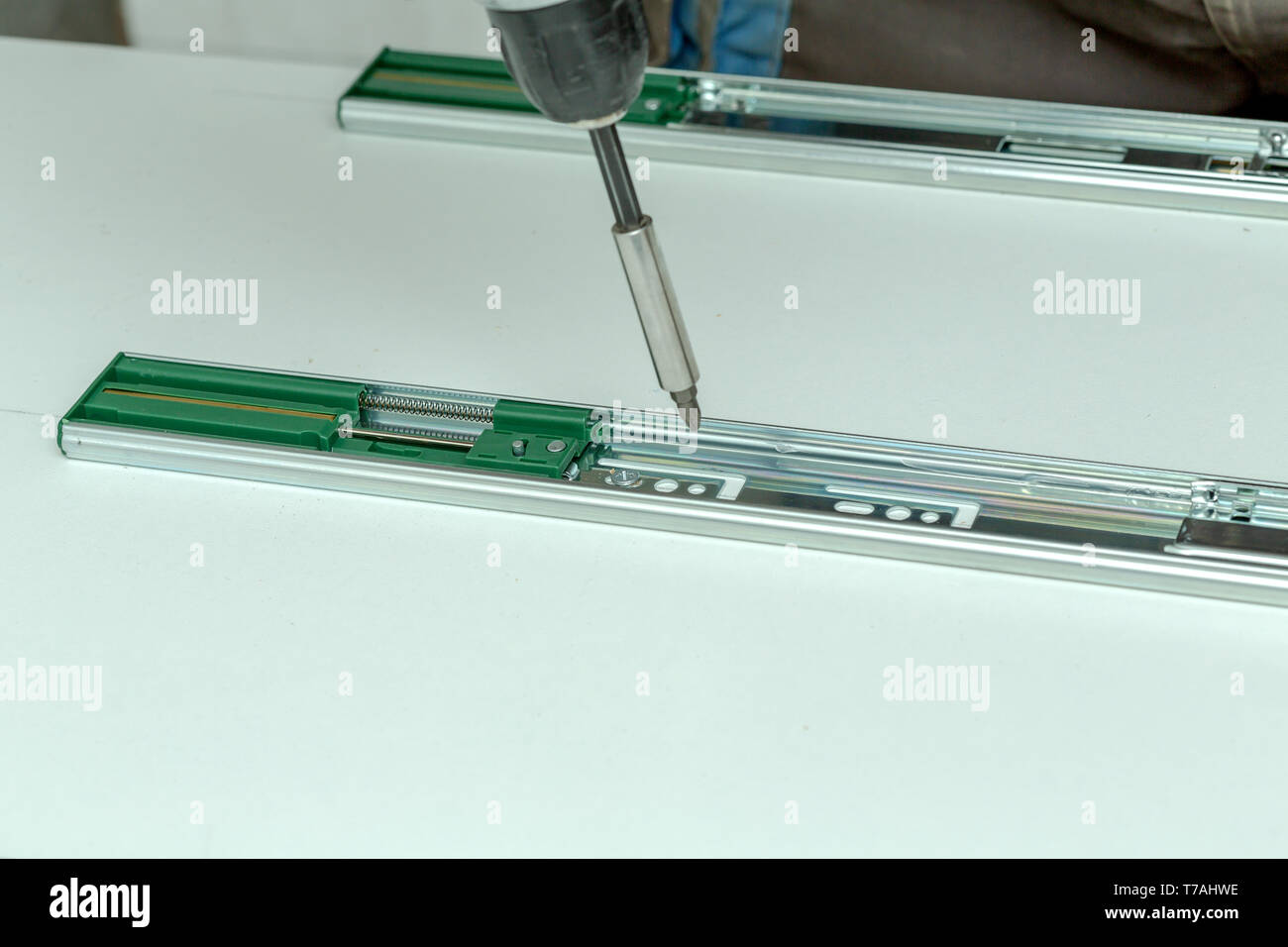 Assembling furniture from chipboard, using a cordless screwdriver, close up Stock Photo