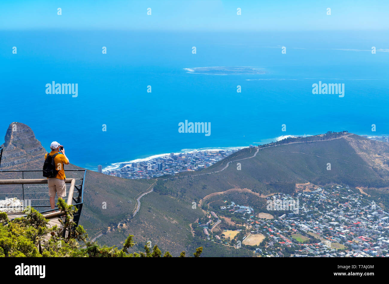 Tourist taking a picture of Robben Island and Signal Hill from the top of Table Mountain, Cape Town, Western Cape, South Africa Stock Photo